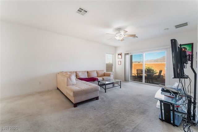 carpeted living room featuring a ceiling fan and visible vents