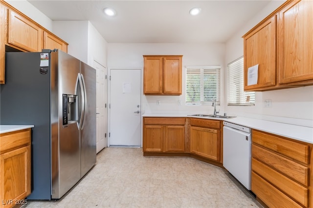 kitchen featuring dishwasher, light countertops, stainless steel refrigerator with ice dispenser, a sink, and recessed lighting