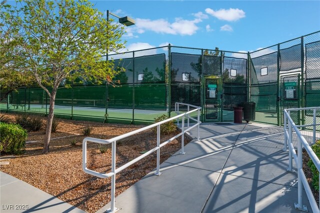 view of community with a tennis court, a gate, and fence