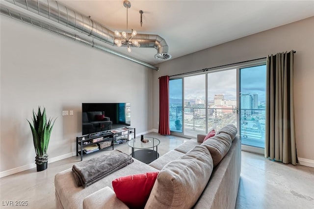 living room with concrete floors, baseboards, and a chandelier