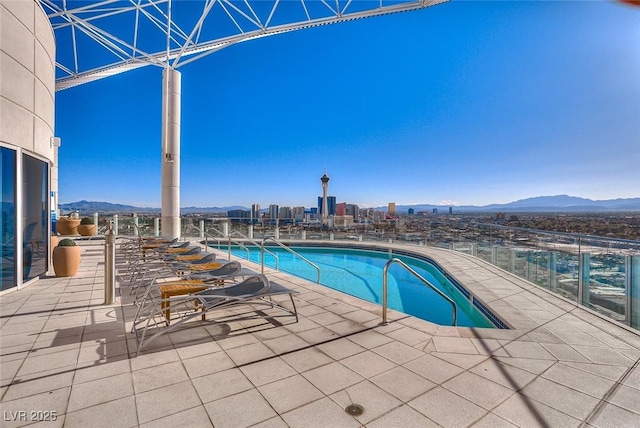 pool with a patio area and a mountain view