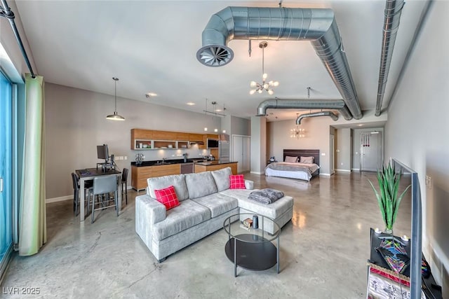 living area featuring finished concrete flooring, baseboards, and an inviting chandelier