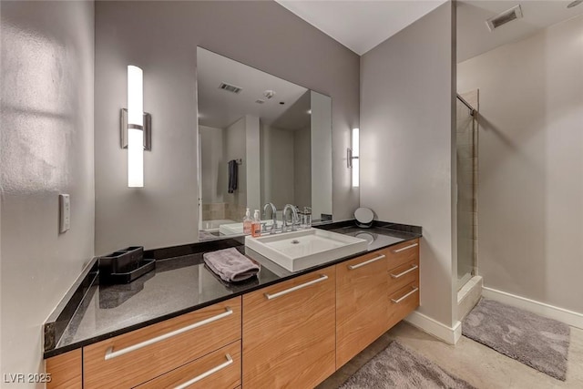 bathroom featuring visible vents, a shower stall, baseboards, and vanity