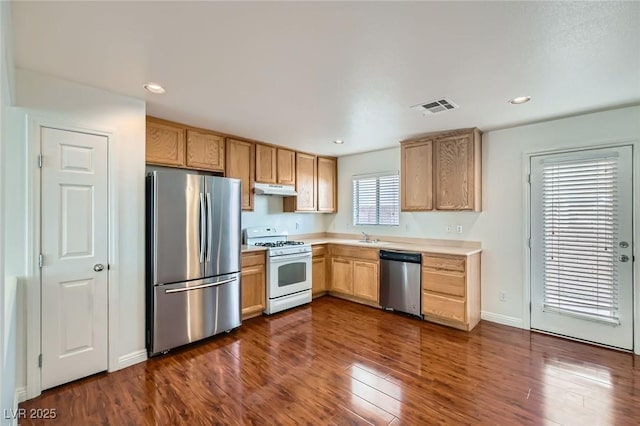 kitchen with visible vents, appliances with stainless steel finishes, dark wood-style flooring, light countertops, and under cabinet range hood