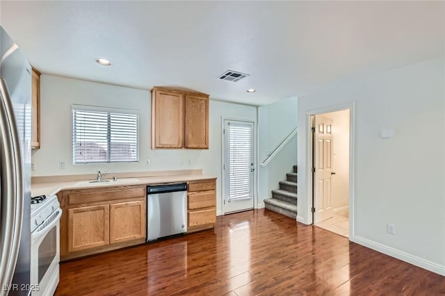 kitchen with stainless steel appliances, light countertops, visible vents, dark wood-type flooring, and a sink