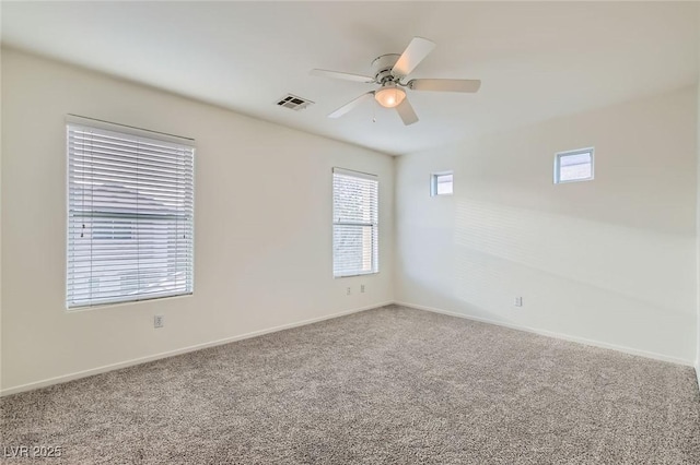 carpeted spare room with ceiling fan, visible vents, and baseboards