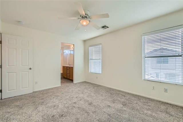 unfurnished bedroom with visible vents, ensuite bathroom, light carpet, ceiling fan, and baseboards