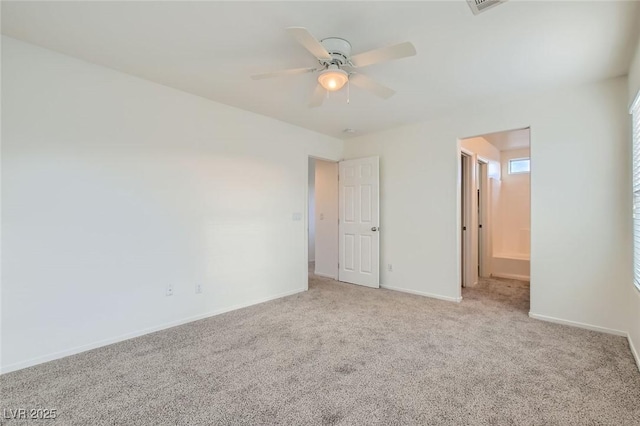 unfurnished bedroom with light carpet, connected bathroom, a ceiling fan, and baseboards