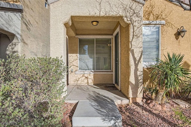 entrance to property featuring stucco siding