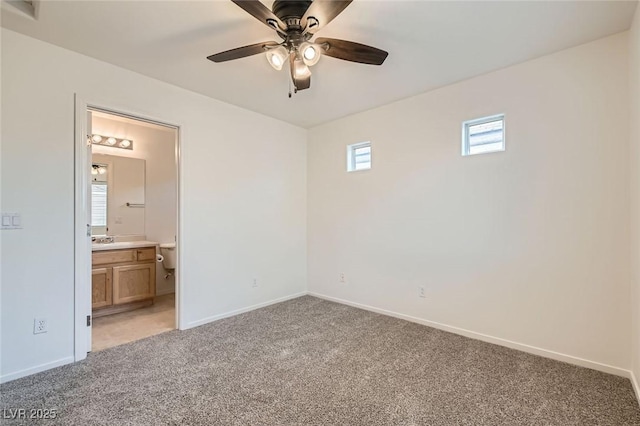 unfurnished bedroom with light colored carpet, ensuite bath, and baseboards