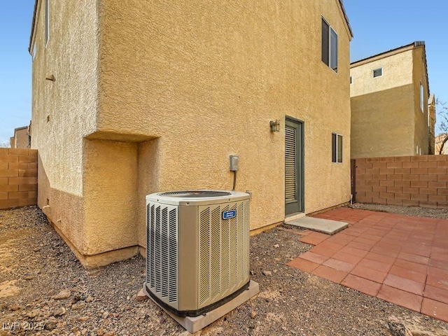 exterior space with a patio area, stucco siding, a fenced backyard, and central air condition unit