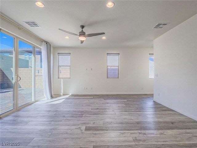 unfurnished room featuring ceiling fan, wood finished floors, and visible vents