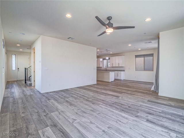 unfurnished living room featuring a ceiling fan, recessed lighting, visible vents, and light wood-style flooring