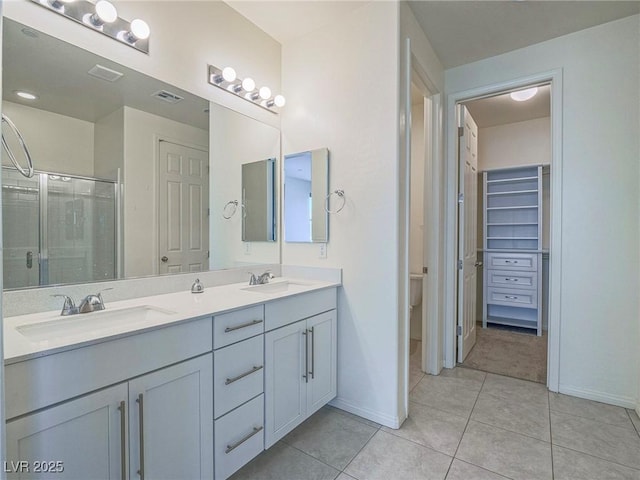 bathroom with a stall shower, tile patterned flooring, a sink, and double vanity