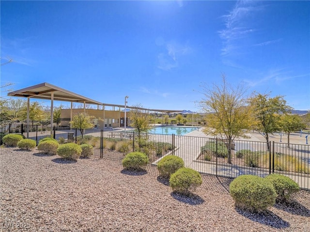 view of home's community with a pool and fence