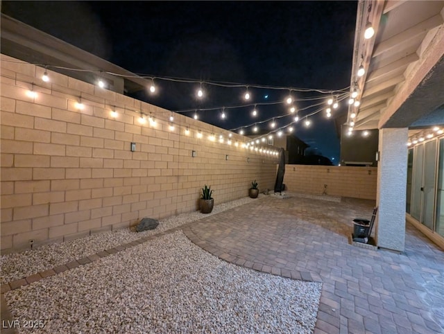 patio at twilight with a fenced backyard