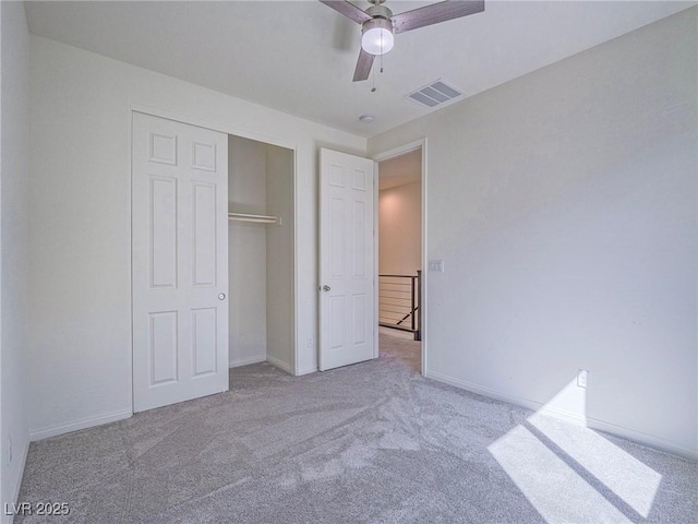 unfurnished bedroom with carpet flooring, a ceiling fan, visible vents, baseboards, and a closet