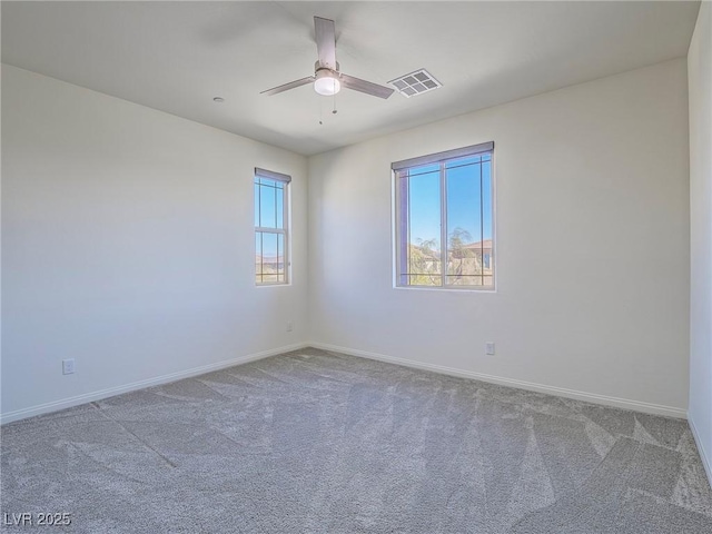 empty room featuring a ceiling fan, baseboards, visible vents, and carpet flooring