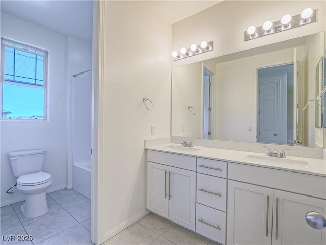 bathroom with a sink, toilet, and tile patterned floors