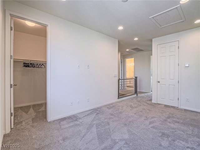 carpeted spare room with baseboards, visible vents, attic access, and recessed lighting