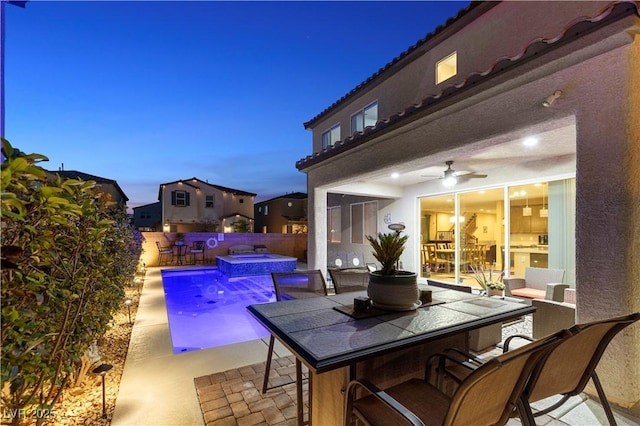 view of pool with a pool with connected hot tub, fence, a patio, and outdoor dining space