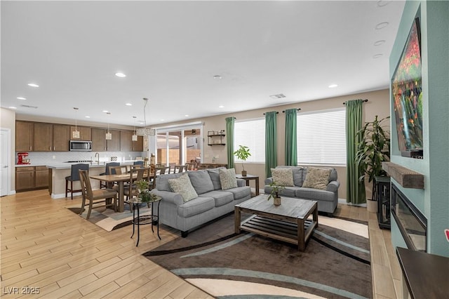 living room featuring light wood-style floors, recessed lighting, and visible vents