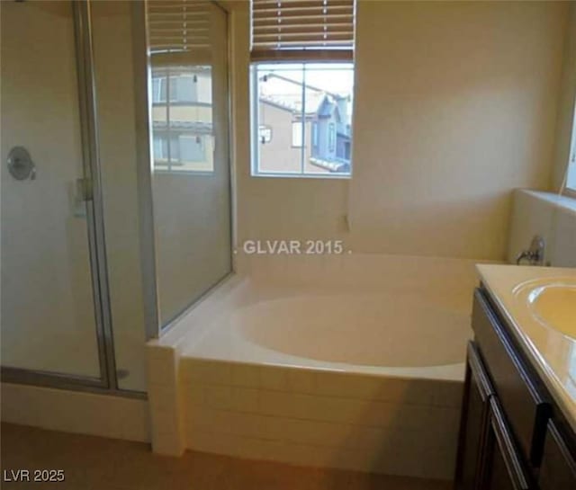 full bath featuring a stall shower, a garden tub, and vanity