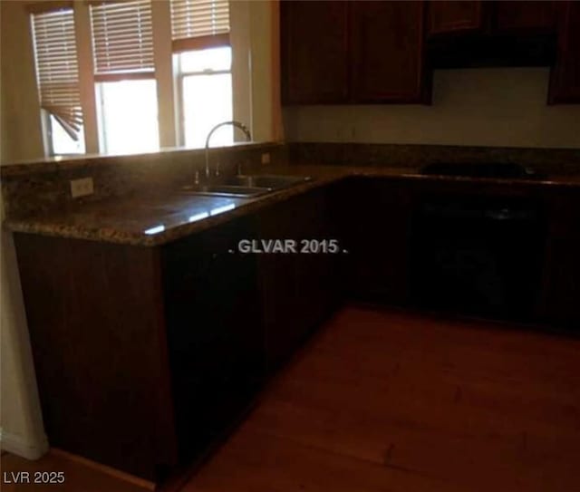 kitchen featuring a peninsula, stovetop, and a sink