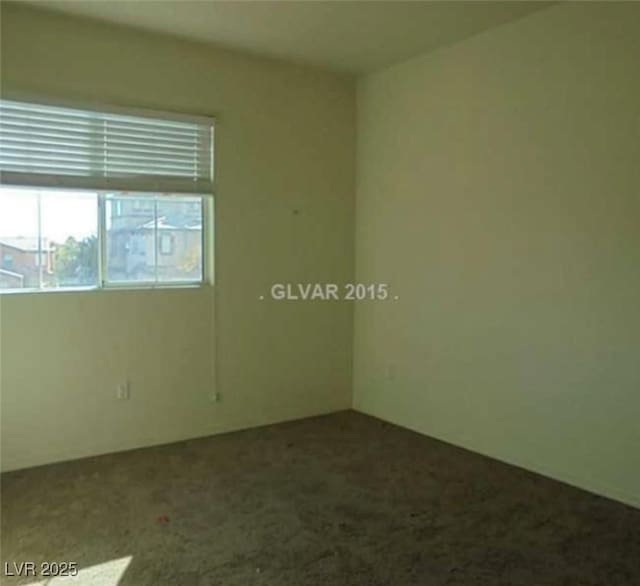 empty room featuring dark colored carpet