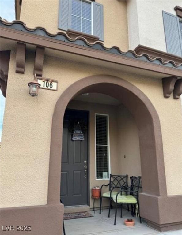 doorway to property featuring stucco siding