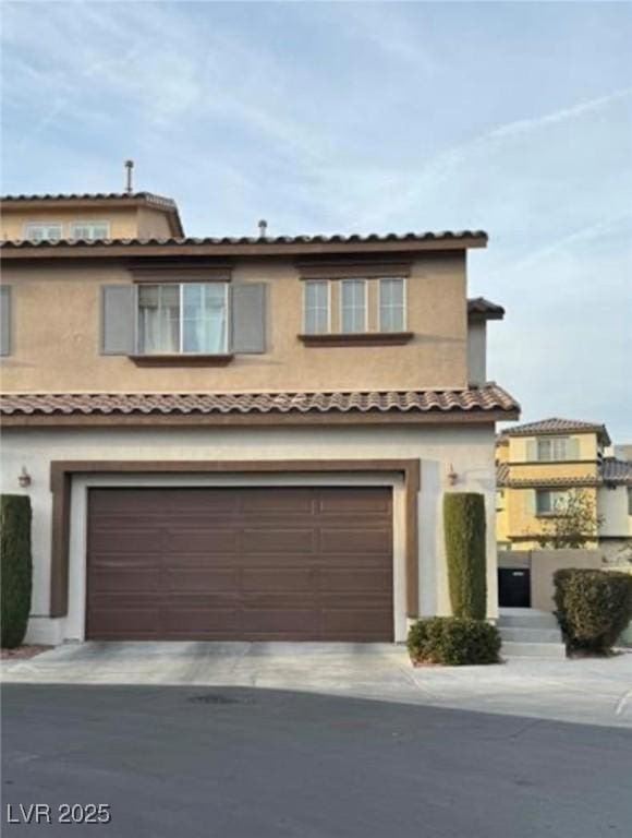 view of front of property with driveway, an attached garage, and stucco siding