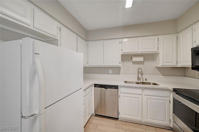 kitchen featuring white cabinetry, stainless steel appliances, a sink, and light countertops