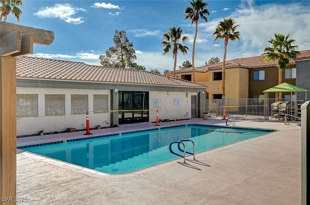 pool with a patio and fence