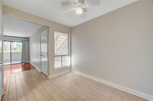 spare room with baseboards, ceiling fan, and wood tiled floor