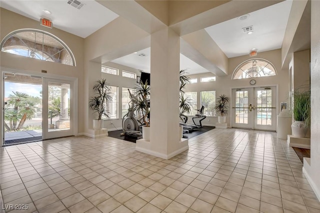 interior space featuring french doors, light tile patterned flooring, visible vents, and baseboards