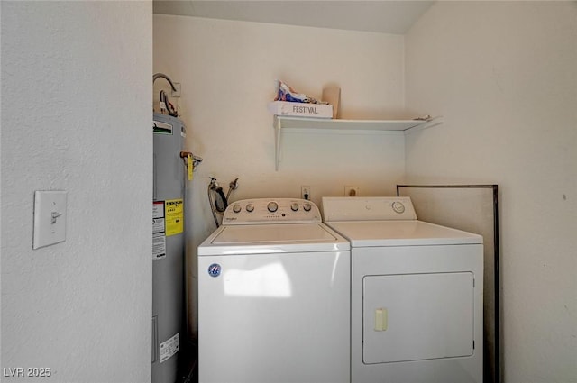 washroom with water heater, laundry area, and washing machine and dryer