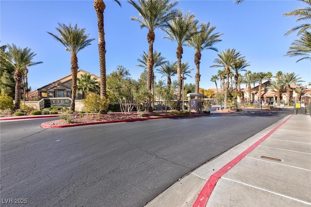 view of street with sidewalks, a gate, and curbs