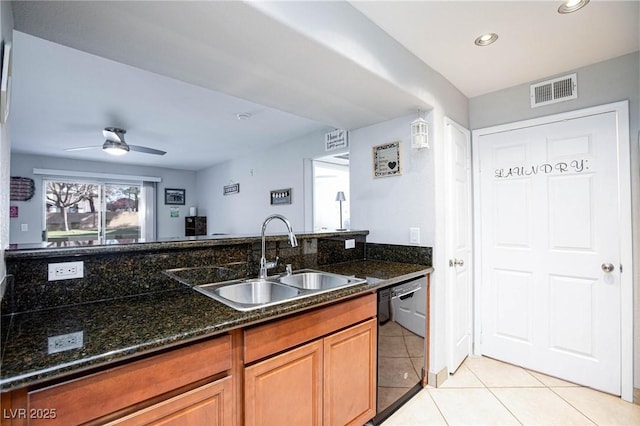 kitchen featuring black dishwasher, visible vents, dark stone counters, a sink, and light tile patterned flooring