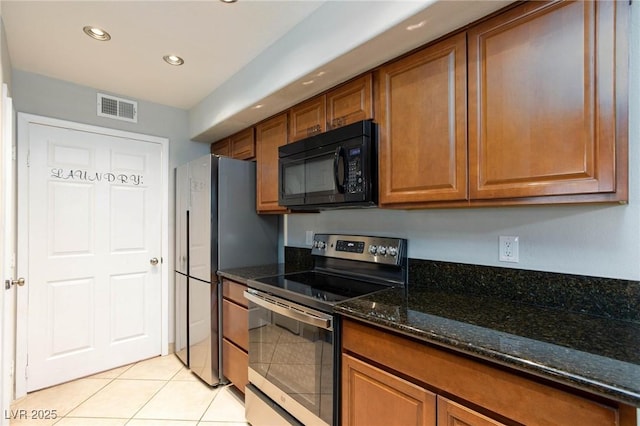 kitchen with electric stove, black microwave, and brown cabinetry