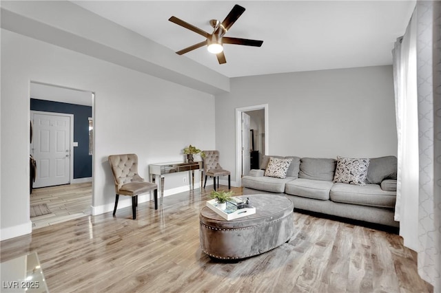 living area with ceiling fan, baseboards, vaulted ceiling, and wood finished floors