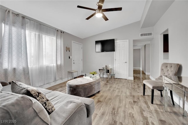 living room with visible vents, light wood-style flooring, a ceiling fan, vaulted ceiling, and baseboards