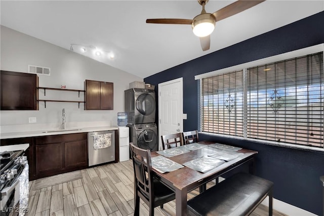 dining space with stacked washer and dryer, visible vents, lofted ceiling, ceiling fan, and light wood-type flooring