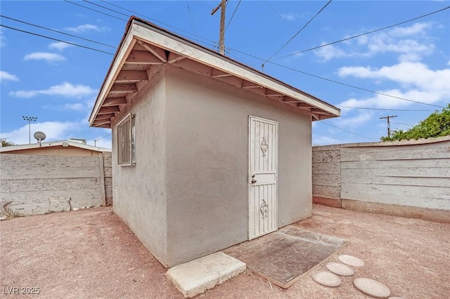 view of outbuilding with fence and an outdoor structure