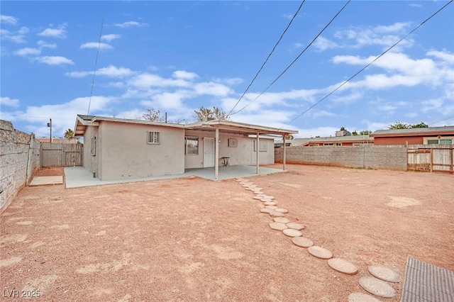 rear view of property featuring a patio area, a fenced backyard, and stucco siding