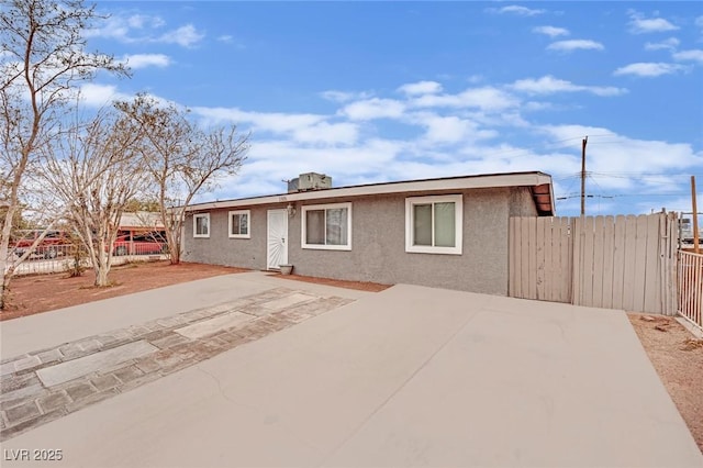 ranch-style house featuring a patio area, fence, and stucco siding