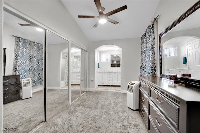 interior space featuring vaulted ceiling, vanity, baseboards, and ceiling fan