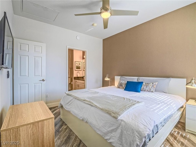 bedroom with ceiling fan, ensuite bath, wood finished floors, and baseboards