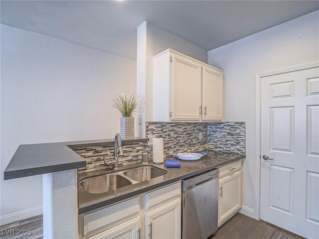 7111 S Durango Dr Unit 305, Las Vegas, NV 89113 - kitchen with stainless steel dishwasher, dark countertops, backsplash, white cabinetry, and a peninsula