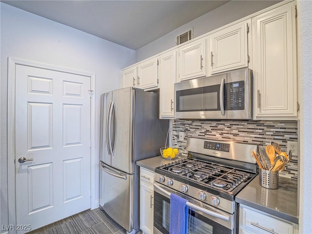 kitchen featuring stainless steel appliances, white cabinets, visible vents, and decorative backsplash