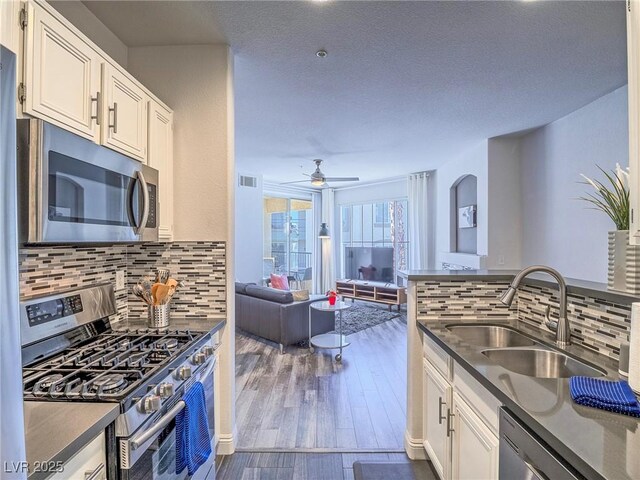 7111 S Durango Dr Unit 305, Las Vegas, NV 89113 - kitchen with appliances with stainless steel finishes, dark countertops, ceiling fan, white cabinetry, and a textured ceiling